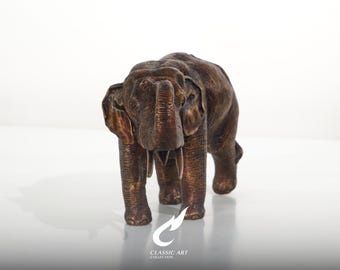 Escultura de elefante asiático em latão, com a tromba erguida em pose de sorte, figura detalhada de animal selvagem.