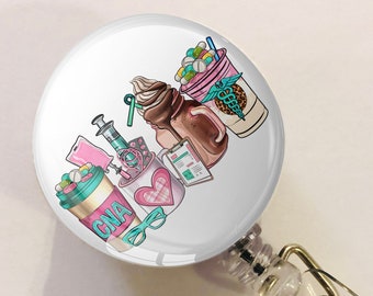 May include: A white retractable badge holder with a round, colorful graphic featuring a coffee cup, a syringe, a stethoscope, and the text "CNA".