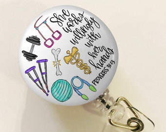 May include: A white button with a colorful illustration of various fitness equipment and the text "She works willingly with her hands" Proverbs 31:13. The button is attached to a clear plastic retractable badge holder with a gold metal clip.
