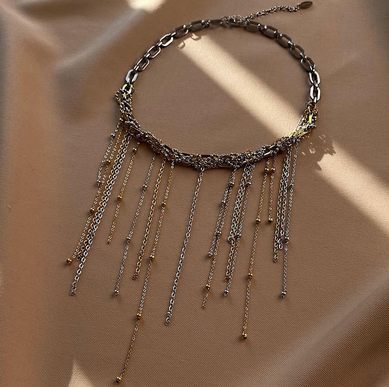 A Mixed Metal Necklace featuring a Fringe Necklace design (Waterfall Necklace). The Two Tone Jewelry set combines silver and gold chains. Includes Rectangular Hoops.
