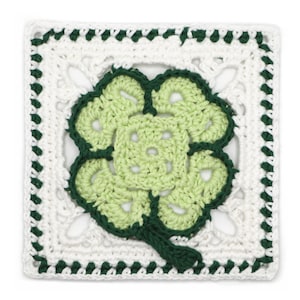 Peut inclure: Napperon carré au crochet avec un motif de trèfle à quatre feuilles. Le trèfle est vert clair avec des contours vert foncé et une tige, sur un fond blanc avec une bordure vert foncé. Le napperon mesure environ 20 cm de côté.