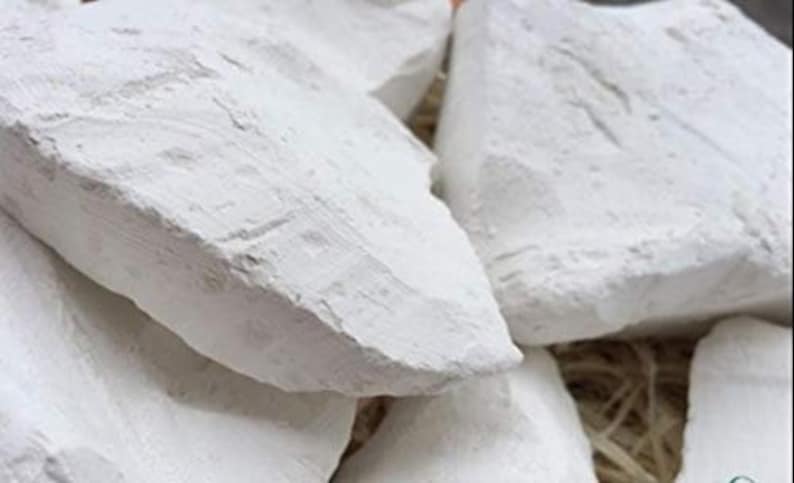 May include: Close-up of several white chalk rocks, showing their rough, textured surfaces. The rocks are piled together, creating a natural and earthy aesthetic.