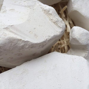 May include: Close-up of a pile of white chalk rocks. The rocks are rough and have a natural, unpolished texture.