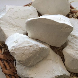 May include: A close-up of a basket filled with white clay rocks. The rocks are various sizes and shapes, and they are all smooth and white.