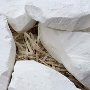 May include: White chalk rocks in a pile, with a natural, rough texture. The rocks are arranged in a basket filled with straw.