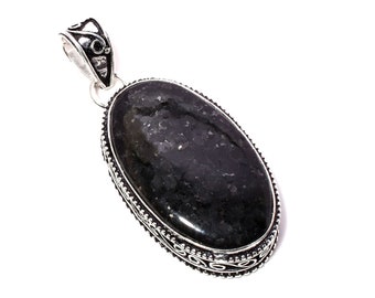 May include: A silver pendant with an oval-shaped black gemstone set in a decorative silver frame.