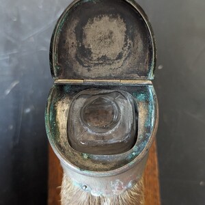 May include: A vintage glass inkwell with a hinged lid, made of brass and mounted on a piece of animal fur.