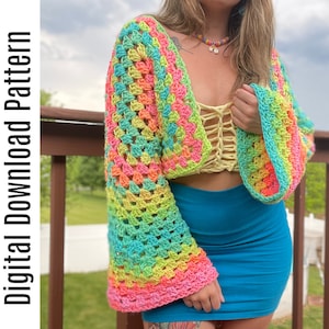 May include: A rainbow crochet top with a wide, bell-shaped sleeve. The top is cropped and has a loose, open-weave design.