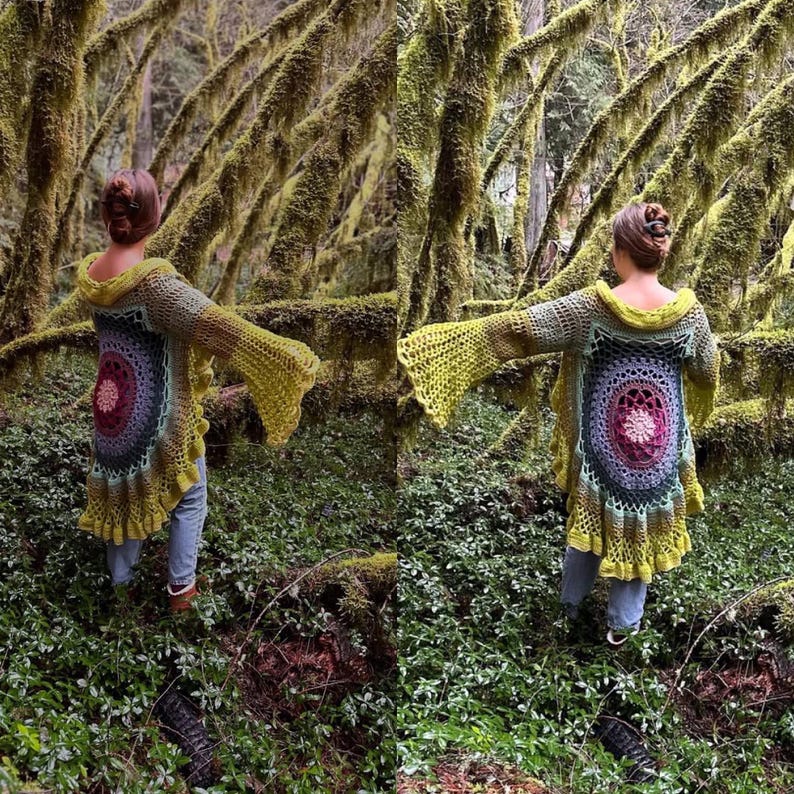 May include: A person wearing a crocheted cardigan with a colorful mandala design in the back. The cardigan has long sleeves and a flowing hem. The person is standing in a forest setting with moss-covered trees.