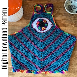May include: A crochet halter top with a colorful eye design in the center. The top is made with teal and burgundy yarn and has a rainbow trim.