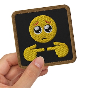 May include: A square embroidered patch featuring a yellow emoji face with large, sad, watery eyes and a small frown. The emoji has two yellow hands positioned below it with index fingers pointing toward each other. The patch has a black background and a brown border.