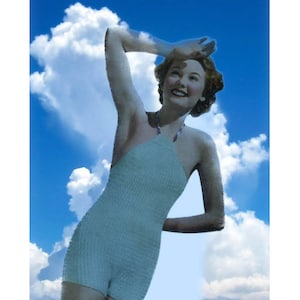 May include: A woman in a light blue swimsuit poses against a blue sky with white clouds. She is smiling and looking up.