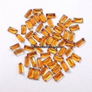 Könnte beinhalten: Ein Haufen von etwa 50 kleinen, rechteckigen, orange-braunen Edelsteinen. Die Edelsteine sind facettiert und haben eine glänzende Oberfläche.