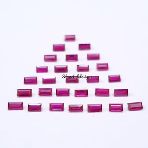 Può includere: Una collezione di 25 pietre preziose rettangolari rosa disposte a forma di triangolo. Le pietre preziose sono tutte della stessa dimensione e forma, e sono disposte in modo simmetrico. Le pietre preziose sono tutte incastonate in una montatura trasparente e chiara.