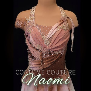 May include: A sleeveless dance costume featuring a gradient of light pink to dark brown fabric with a sheer mesh neckline. The bodice is heavily embellished with clear crystals, sequins, and intricate floral lace appliqués. Text reads COSTUME COUTURE Naomi.