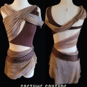 Puede incluir: Un vestido de patinaje art&iacute;stico personalizado con un corpi&ntilde;o marr&oacute;n y una falda de capas en tonos marrones y beige. El vestido presenta un dise&ntilde;o cruzado en el corpi&ntilde;o y una superposici&oacute;n transparente. El vestido est&aacute; adornado con pedrer&iacute;a.