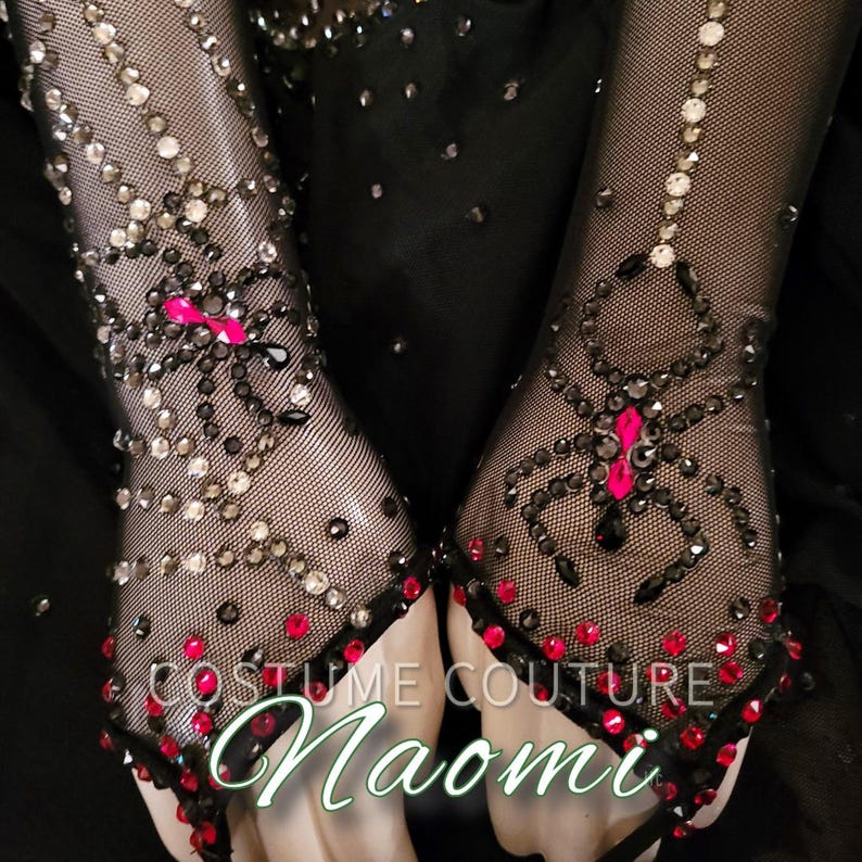 Puede incluir: Guantes de malla negros adornados con brillantes pedrer&iacute;a y detalles rojos y negros. El dise&ntilde;o presenta un motivo de ara&ntilde;a con detalles rosas. El texto "COSTUME COUTURE Naomi" es visible en los guantes.