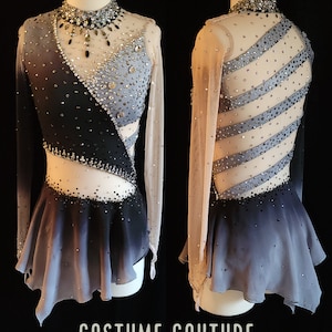 May include: A black and gray figure skating dress with long sleeves and a sheer bodice. The dress has a gradient skirt and is decorated with rhinestones. The dress is on a mannequin and the text "COSTUME COUTURE by Naomi" is at the bottom of the image.