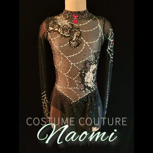 Puede incluir: Un vestido negro de patinaje art&iacute;stico con mangas largas, con un dise&ntilde;o de telara&ntilde;a con cuentas blancas y plateadas. El corpi&ntilde;o tiene detalles florales y de ara&ntilde;as, con detalles rojos y negros. El texto "COSTUME COUTURE Naomi" est&aacute; en la parte inferior.