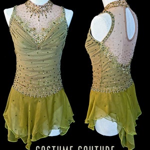 May include: A green and gold figure skating dress with a high neckline and a sheer bodice. The dress is embellished with rhinestones and beads. The skirt is layered and has a ruffled hem. The dress is on a white mannequin. The text "COSTUME COUTURE by Naomi" is at the bottom of the image.