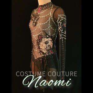 Puede incluir: Un disfraz negro y color piel con un dise&ntilde;o de telara&ntilde;a. La prenda de manga larga est&aacute; adornada con pedrer&iacute;a y detalles rojos. El texto "COSTUME COUTURE Naomi" est&aacute; en la parte inferior de la imagen.