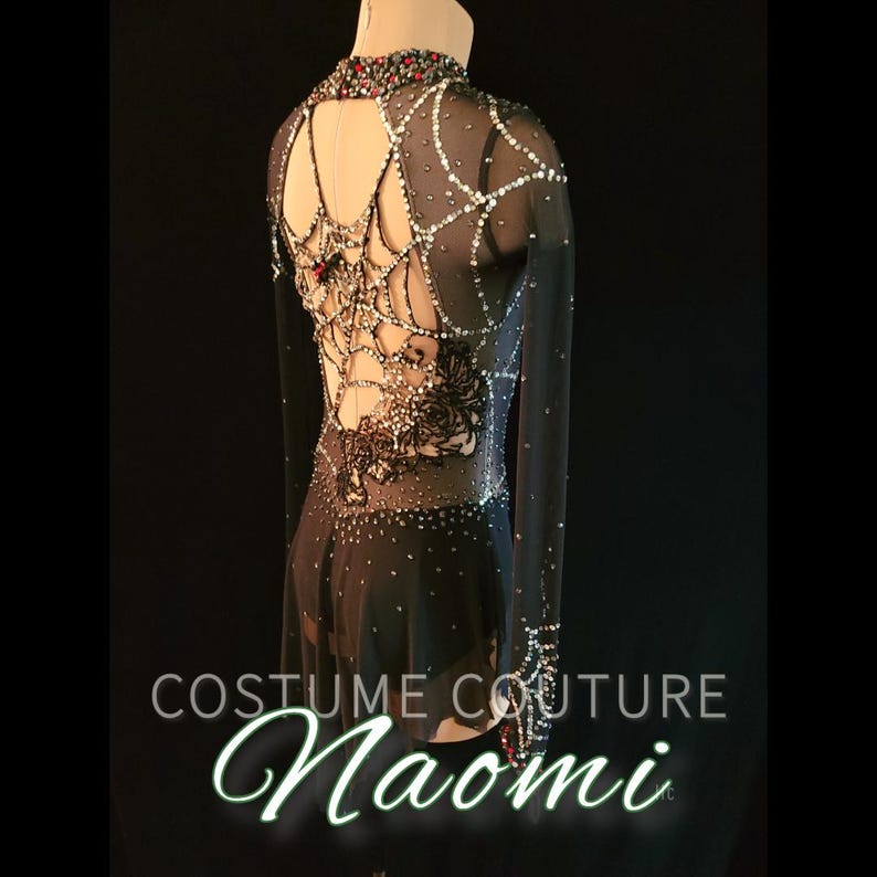 Puede incluir: Vestido de disfraz negro de manga larga con cuello alto y espalda abierta. El vestido est&aacute; adornado con pedrer&iacute;a plateada y roja, y un dise&ntilde;o de telara&ntilde;a. El texto "Costume Couture Naomi" est&aacute; en la parte inferior de la imagen.