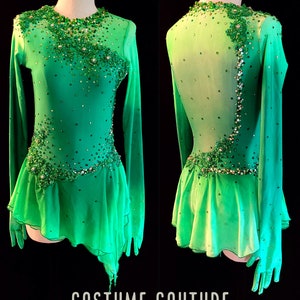 Puede incluir: Un vestido de patinaje art&iacute;stico verde con mangas largas y espalda transparente. El vestido est&aacute; decorado con pedrer&iacute;a y lentejuelas. El vestido tiene una falda corta con un dobladillo con volantes. El vestido est&aacute; dise&ntilde;ado por Costume Couture by Naomi.