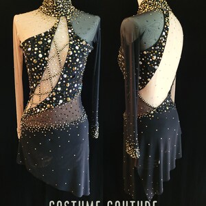 May include: A black dance costume with long sleeves and a high neckline. The costume is embellished with gold and black rhinestones and features a sheer panel on the back. The costume is displayed on a mannequin.