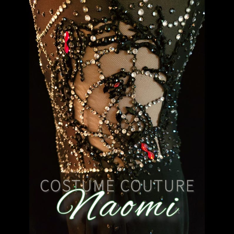 Puede incluir: Primer plano de un disfraz negro con intrincados abalorios y pedrer&iacute;a. El dise&ntilde;o presenta un patr&oacute;n similar a una telara&ntilde;a con acentos rojos. El texto "COSTUME COUTURE Naomi" es visible en la parte inferior.