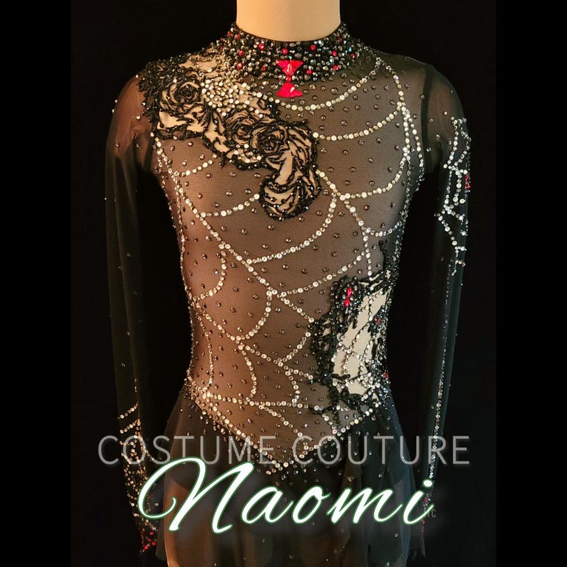 Puede incluir: Vestido negro de patinaje art&iacute;stico con mangas largas, cuello alto y corpi&ntilde;o transparente. El vestido presenta un dise&ntilde;o de telara&ntilde;a con detalles plateados y rojos, rosas de encaje negro y el texto "COSTUME COUTURE Naomi".