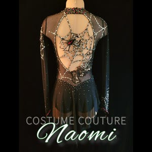 Puede incluir: Vestido negro de patinaje art&iacute;stico con mangas largas, espalda abierta y dise&ntilde;o de telara&ntilde;a. El vestido est&aacute; adornado con pedrer&iacute;a y un acento de ara&ntilde;a. El texto "COSTUME COUTURE Naomi" est&aacute; en la parte inferior.