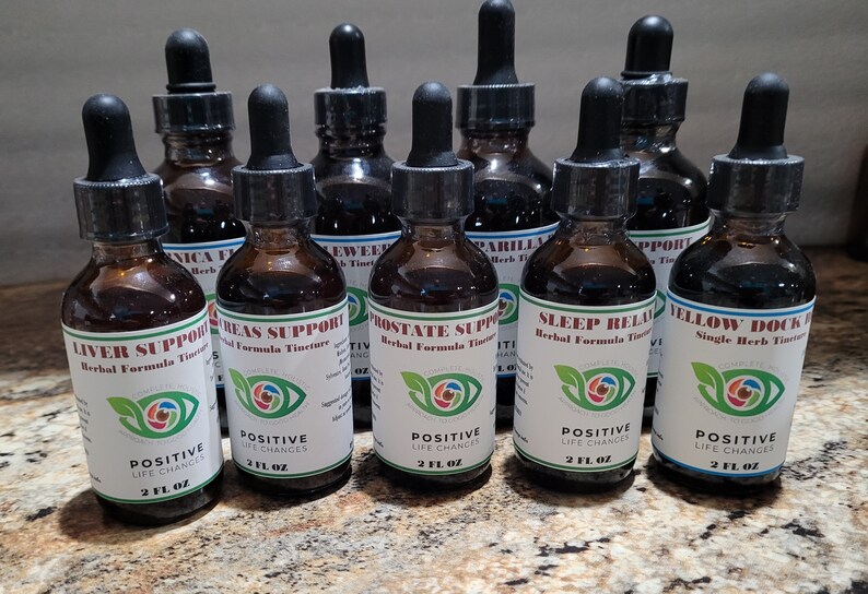 K&ouml;nnte beinhalten: Zehn Glasflaschen mit Tropfern, gef&uuml;llt mit brauner Fl&uuml;ssigkeit. Jede Flasche hat ein wei&szlig;es Etikett mit einem gr&uuml;nen Blattdesign und Text, der "Positive Life Changes" und den Namen einer Kr&auml;uterformel-Tinktur lautet. Die Tinkturen umfassen Liver Support, Breas Support, Prostate Support, Sleep Relax und Yellow Dock.