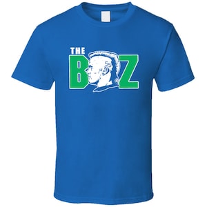 May include: A royal blue t-shirt with a white graphic of a man's head with the text "THE BOZ" in green and white.