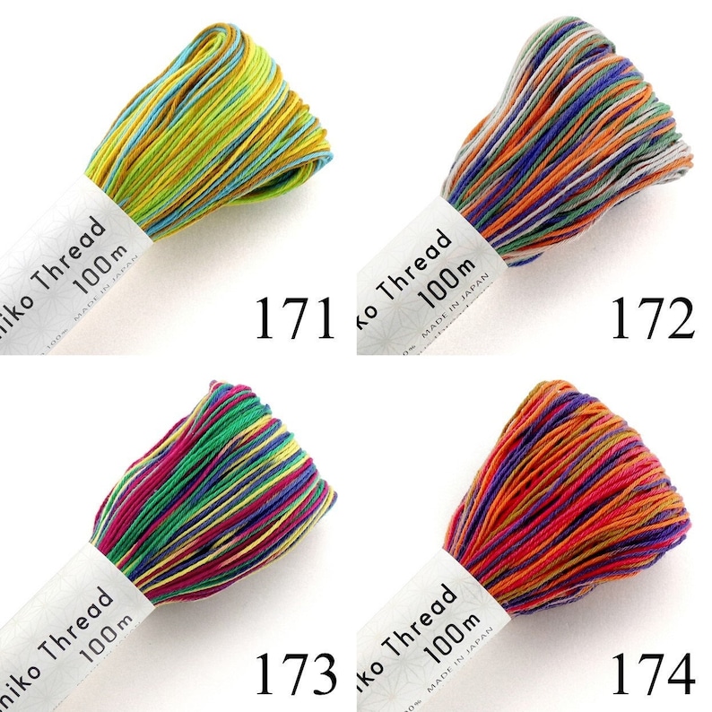 Puede incluir: Cuatro madejas de hilo Sashiko, cada una de 100m, etiquetadas 171, 172, 173 y 174. La madeja 171 es amarilla y verde azulado, la 172 naranja, azul y gris, la 173 magenta, verde y amarilla, y la 174 naranja, morada y roja. Hecho en Jap&oacute;n.