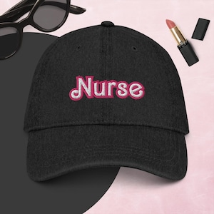 Könnte beinhalten: Schwarze Baseballkappe mit dem in Pink gestickten Wort "Nurse" auf der Vorderseite.