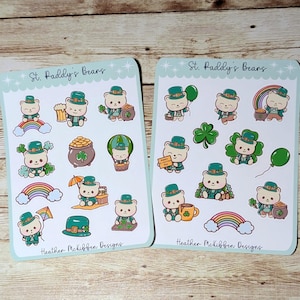 May include: Two sticker sheets featuring St. Paddy's Bears. Each bear is wearing a green hat and is surrounded by St. Patrick's Day themed images, including rainbows, pots of gold, and shamrocks. The text "St. Paddy's Bears" and the designer's name are printed on the sheets.