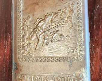 Vintage metal German WW1 cigarette case with trench battle scene.
