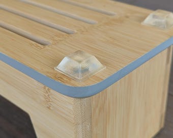 Può includere: Un portacoltelli in bambù con un bordo grigio e piedini in gomma trasparente. Il blocco ha delle fessure per contenere i coltelli.