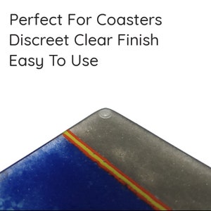 May include: Close-up of a blue, grey, yellow and orange glass coaster with a clear finish. The coaster has a small, clear, round sticker on the bottom.