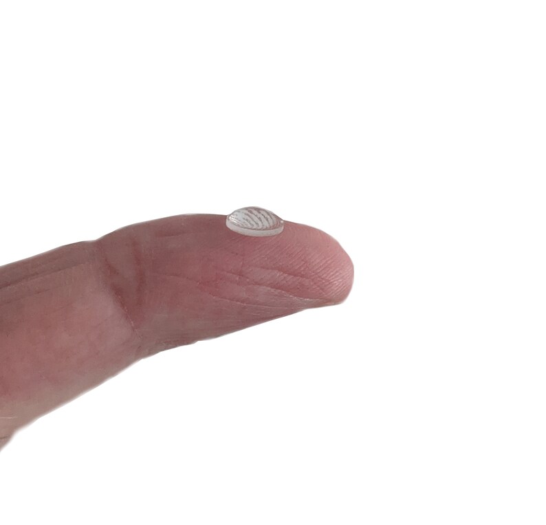May include: A clear, round drop of liquid resting on a fingertip.