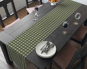 Könnte beinhalten: Ein grüner und beiger karierter Tischläufer auf einem dunklen Holztisch mit zwei Weingläsern und einem Teller mit Besteck.