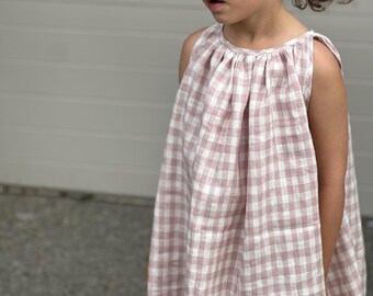 May include: A sleeveless pink and white gingham dress with a gathered neckline.