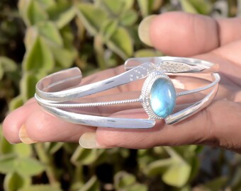 May include: Silver cuff bracelet featuring a blue labradorite gemstone. The bracelet has a delicate design with multiple bands and a textured finish.