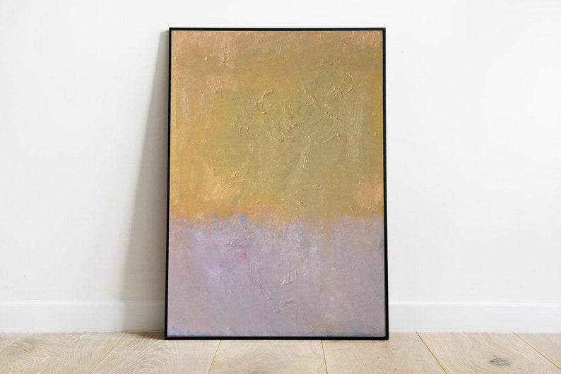 May include: Abstract painting with a textured gold background and a light purple bottom half. The painting is framed in black.