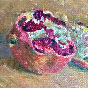 May include: A close-up of a painting of a halved pomegranate with red and white seeds on a brown canvas background.