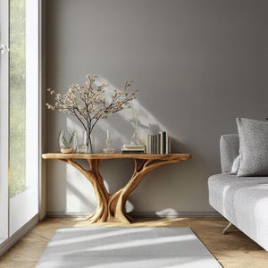 May include: A wooden console table with a unique tree-branch design. The table is adorned with decorative items, including a vase of flowers, books, and candles. The room features a gray sofa, a white rug, and a window with natural light.