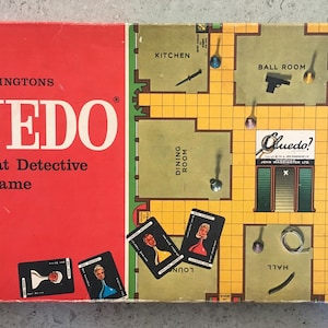Op de afbeelding: Vintage Cluedo bordspel van Waddingtons. De rode doos toont de speltitel en tekst. Het spelbord toont een plattegrond van een huis met kamers zoals de keuken en balzaal, samen met kaarten en pionnen.