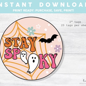 Może przedstawiać: Drukowane okrągłe etykiety o średnicy 5 cm w kolorze różowym, pomarańczowym i białym z tekstem "Stay Spooky" oraz pajęczyną, duchem i nietoperzem. 20 etykiet na arkusz.