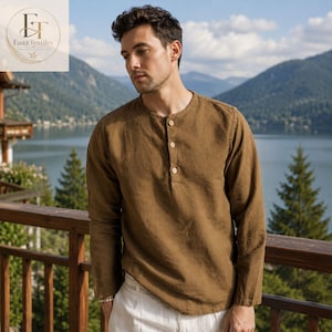 May include: A long-sleeved brown shirt with a round neckline and a partial button-down placket featuring three light-coloured buttons. The shirt has a textured appearance and is paired with white trousers. The Faaz Textiles logo is visible.