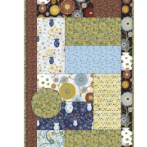 May include: A decorative, vertical quilt featuring a patchwork design with floral and abstract patterns in shades of blue, yellow, brown, and green. The quilt has a dark brown border and circular accents, creating a visually appealing textile.